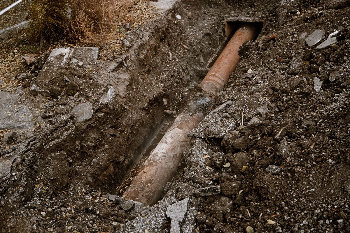 Old Rusty Pipe for water in a trench open for traditional repair, top view