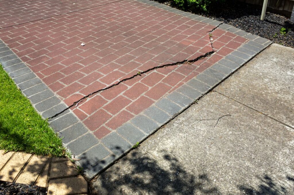 Cracked brick driveway in a residential property