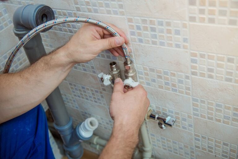 plumber replacing faucet in kitchen