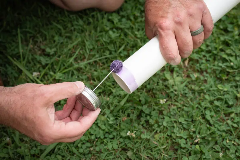 Male hands preparing a pipe with primer to fit together a PVC, polyvinyl chloride, line