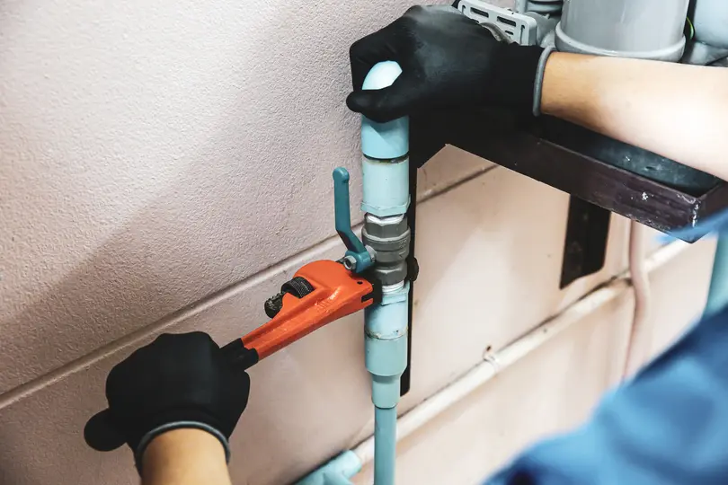 Technician plumber using a wrench to repair a water pump pipe. Concept of maintenance