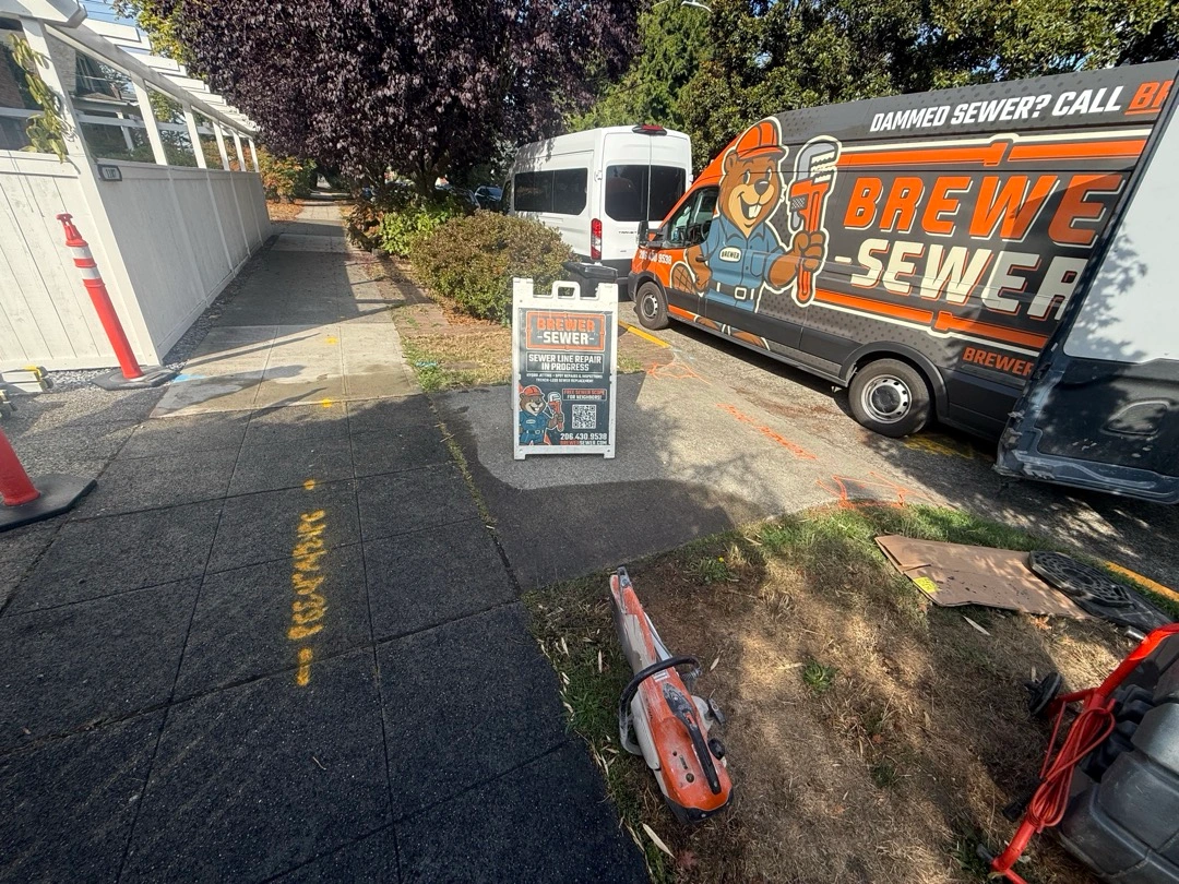 Brewer Sewer van and "Sewer Line Repair in Progress" sign at a residential job site