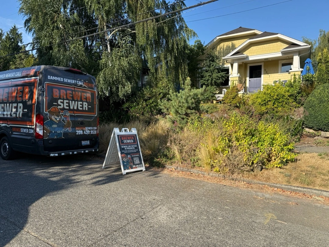 "Sewer Line Repair in Progress" sign and Brewer Sewer van parked in front of a yellow house